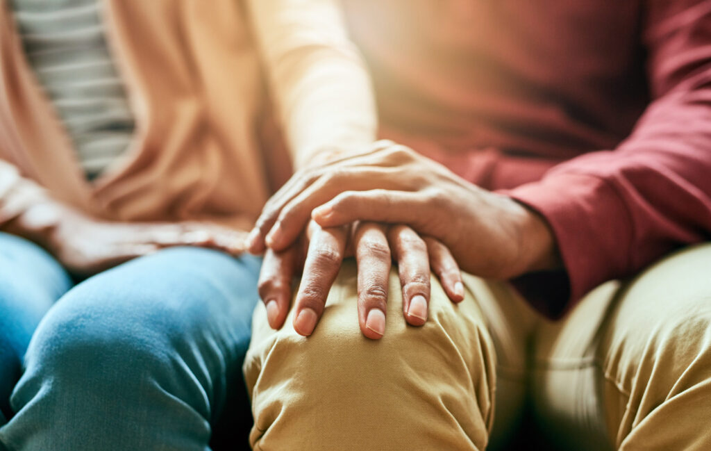 Closeup shot of an unrecognizable couple holding hands in comfort.