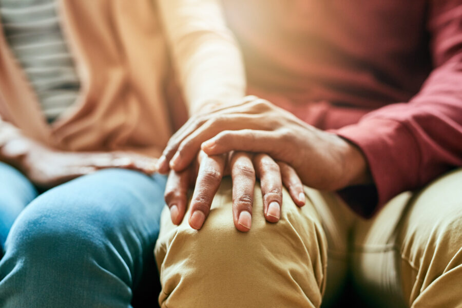 Closeup shot of an unrecognizable couple holding hands in comfort.