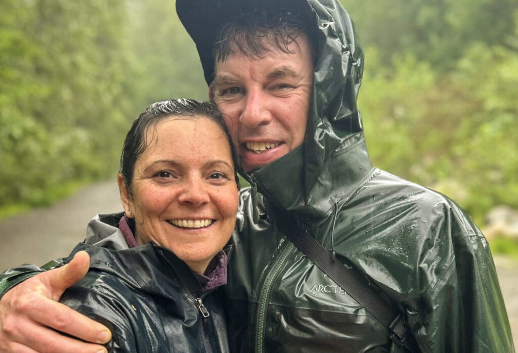 Vancouver couples therapist Justin Morrison and his wife smiling at the camera after a rainy hike