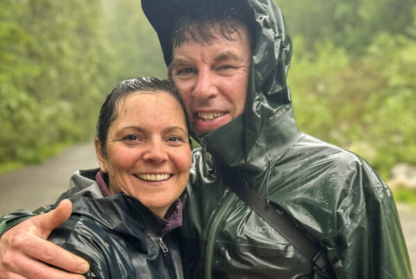 Vancouver couples therapist Justin Morrison and his wife smiling at the camera after a rainy hike